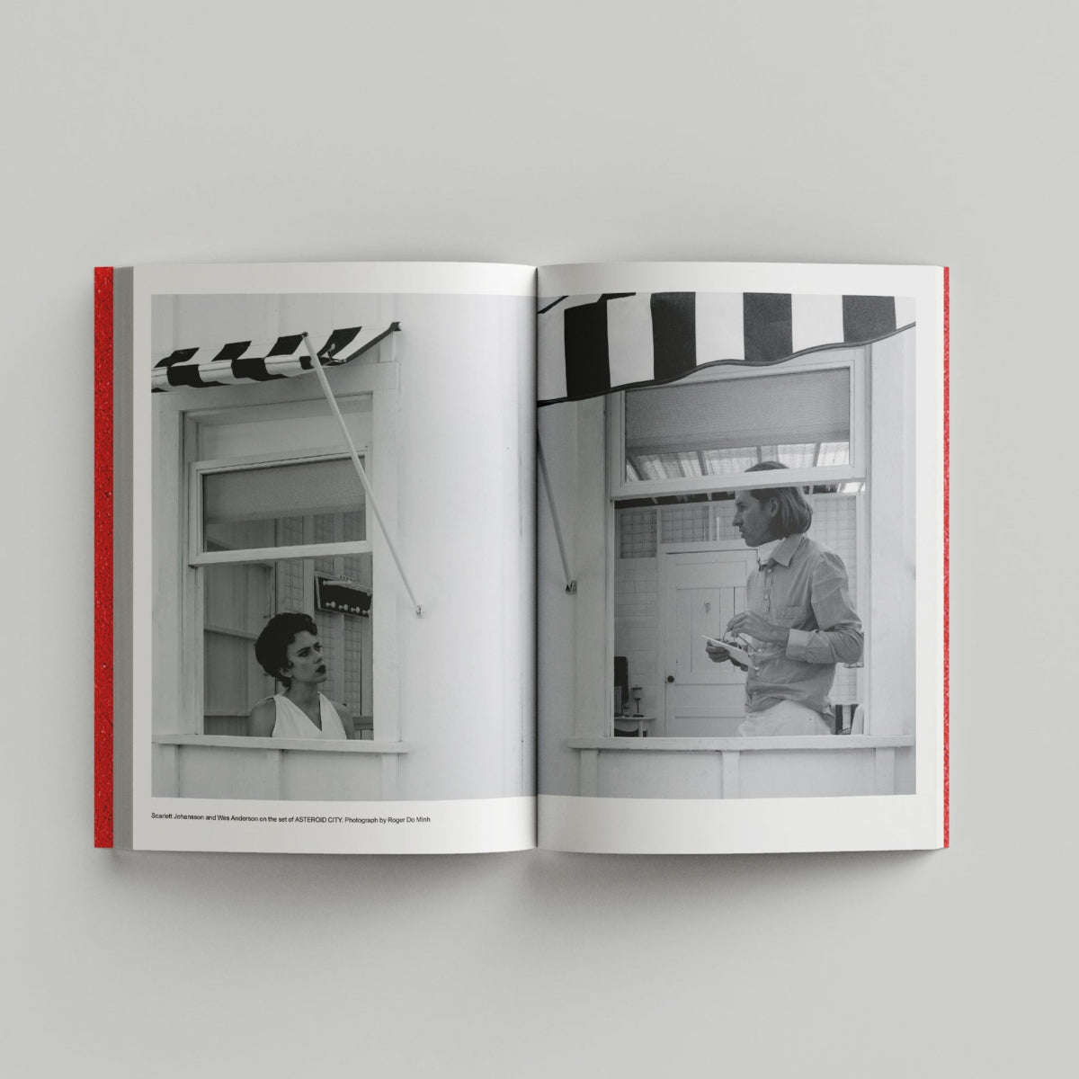 Open book showing black and white photos of a woman in a kitchen.