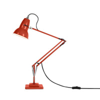 Red Anglepoise desk lamp with a flexible arm on a white background