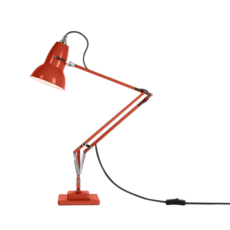 Red Anglepoise desk lamp with a flexible arm on a white background