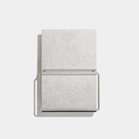 A minimalist rectangular metal bookstand shown open against a clean white background.