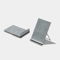 Two metal bookstands on a light gray background, one shown from a top-down view and the other from a side angle displaying its wire stand.