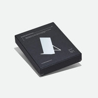 A black rectangular product box for a metal bookstand, photographed on a clean light gray background.