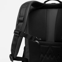 Black backpack with textured back panel and shoulder strap on a white background