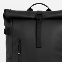 Black roll-top backpack on a light gray background