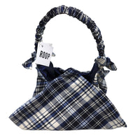 Plaid handbag with 'ROOP' tag held by a hand on a white background