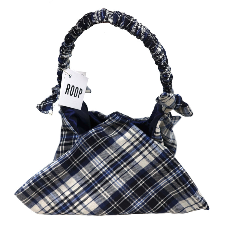 Plaid handbag with 'ROOP' tag held by a hand on a white background