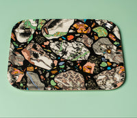 A colourful abstract patterned tray on a light green background