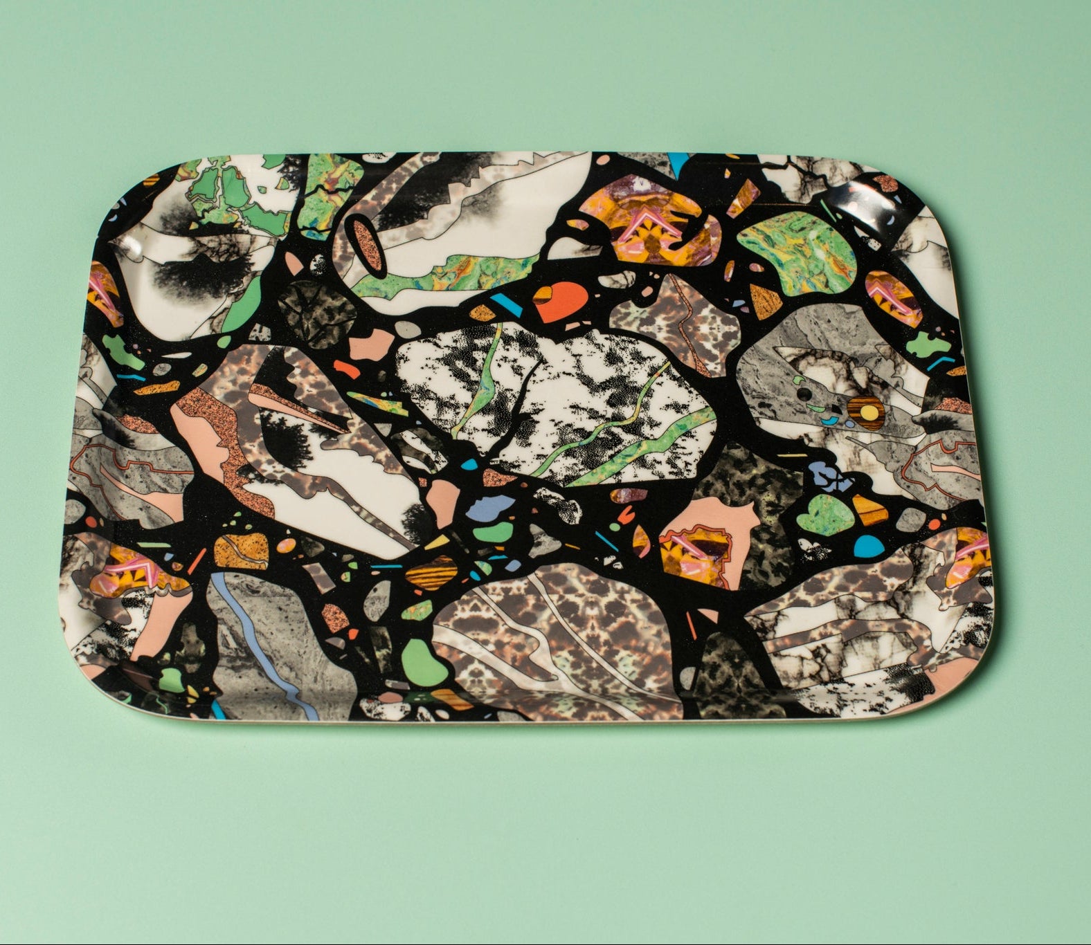 A colourful abstract patterned tray on a light green background