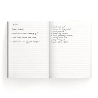 The inside of a notebook featuring lined pages and handwritten notes.