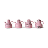 Four pink and black abstract ceramic coffee pots on a white background.