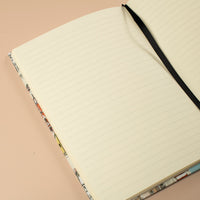 Open notebook with lined pages on a beige background