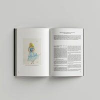 Open page of Tim Burton 'Designing Worlds' catalogue featuring a colourful illustration on the left and a page with text on the right.