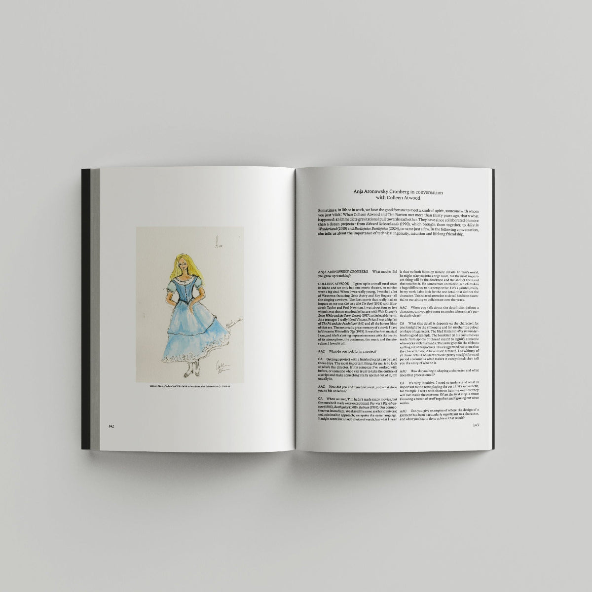 Open page of Tim Burton 'Designing Worlds' catalogue featuring a colourful illustration on the left and a page with text on the right.