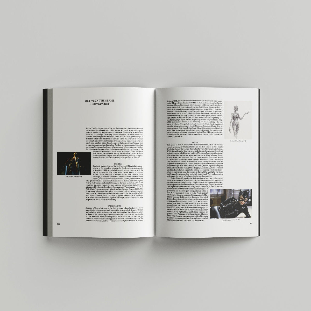 Open page of Tim Burton 'Designing Worlds' catalogue featuring text with small images of cat woman costume designs.