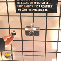 Vintage camera on a grid wall with text above