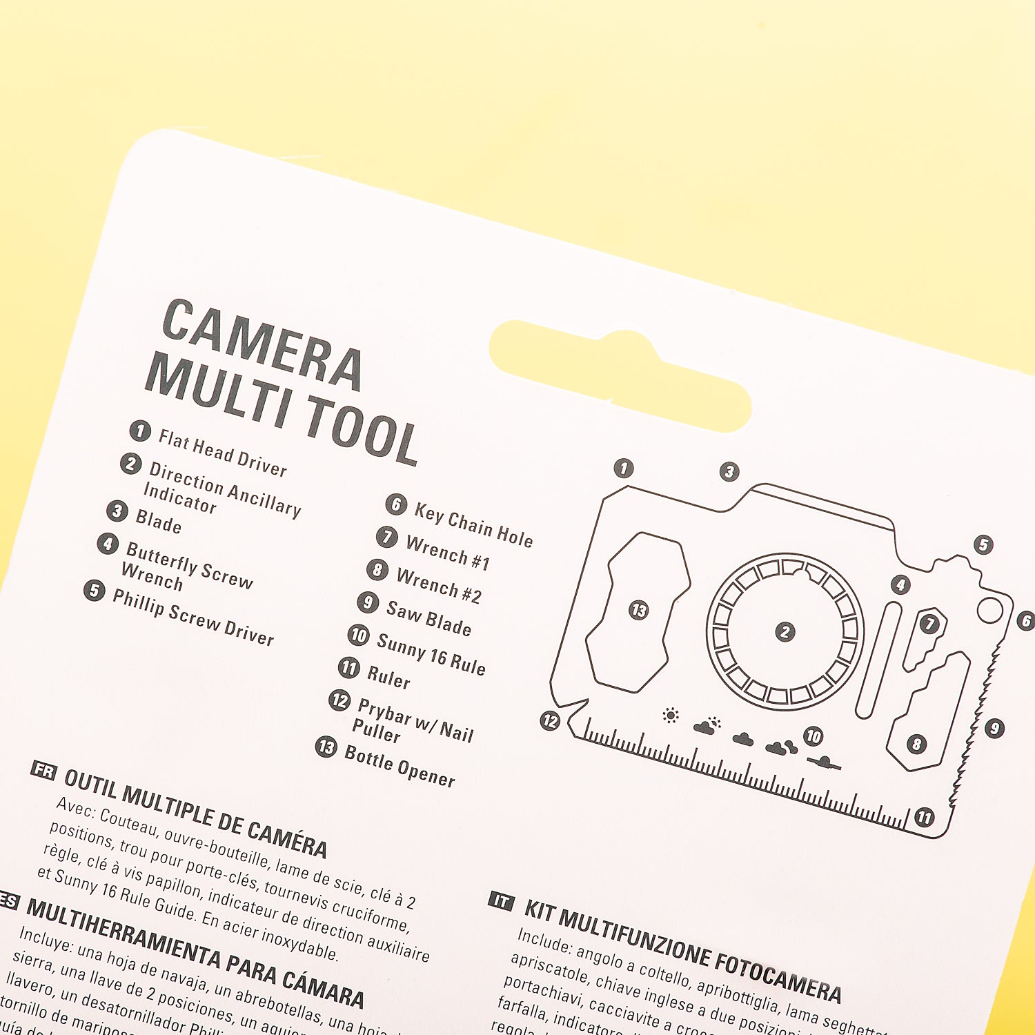 The instructions for a camera multi tool on white cardboard against a pale yellow background. 