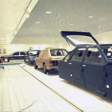 Car on a production line with open doors in a factory setting