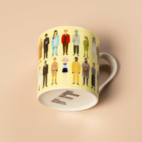 Yellow mug with illustrated characters on a beige background