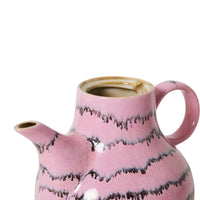 A pink and black abstract ceramic coffee pot without lid on a white background.