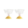 Two glass bowls with yellow bases and pink spheres on a white background