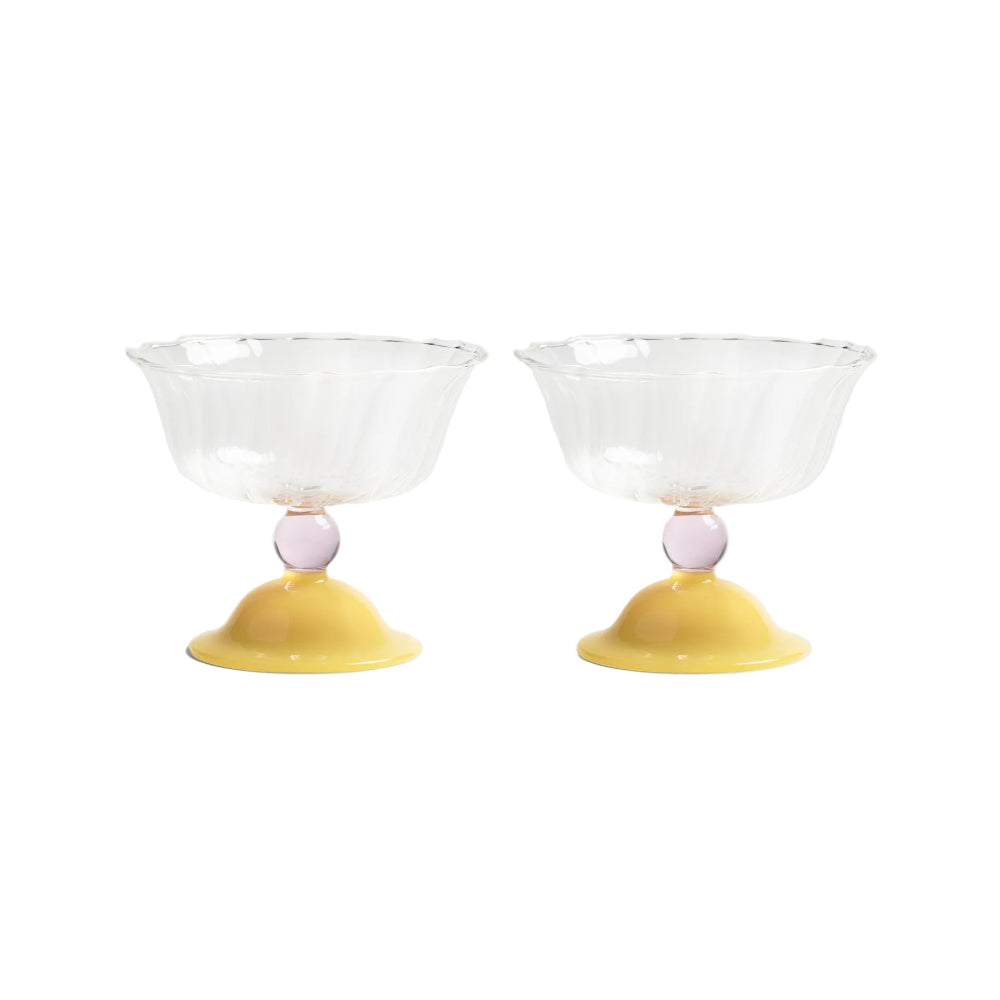 Two glass bowls with yellow bases and pink spheres on a white background