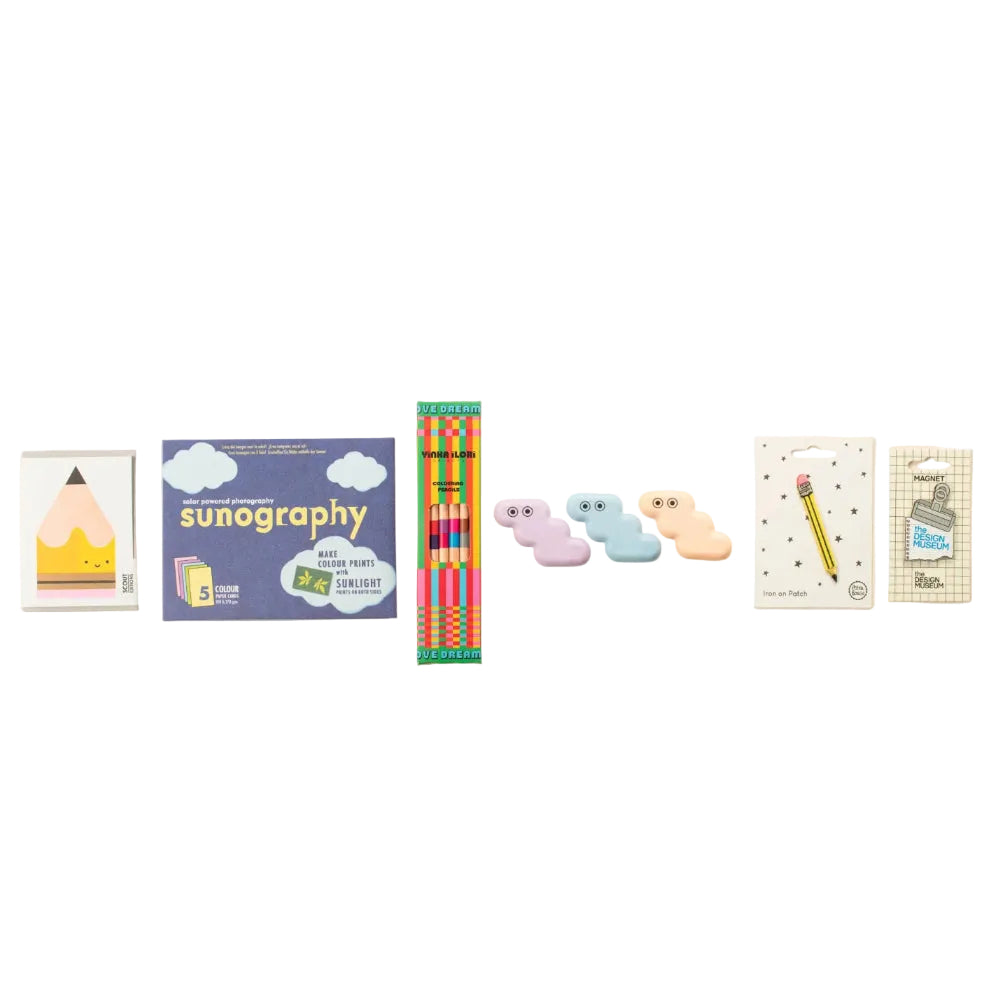 A row of cute, pastel-colored cloud-shaped erasers displayed alongside other stationery items including a sunography book, colored pencils, and a pencil eraser.