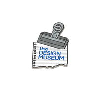 A metal bulldog clip on a notepad maget with 'the Design Museum' text on a white background