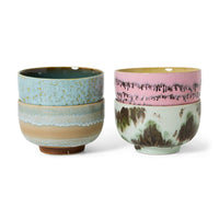 A set of 4 colourful abstract hand-painted ceramic noodle bowls on a white background. 