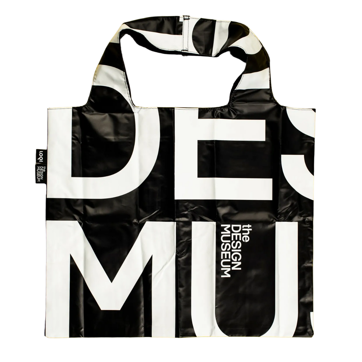 A reusable tote bag with a bold black and white graphic print featuring the words 'DESIGN MUSEUM'. The bag has a glossy, slightly reflective finish and is shown against a plain white background.