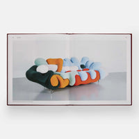 Open page of Designed for Life by Phaidon featuring a photograph of a colourful abstract designed sofa.