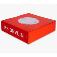 A red box shown on its side with a white circular cut out and 'ES DEVLIN' on the spine