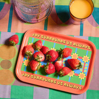 Colourful tray with strawberries and motivational quote on a patterned tablecloth