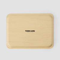 The back of a beige tray with 'YINKA ILORI' branding on a light gray background