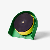 A the back of a green round kitchen timer with a black panel.