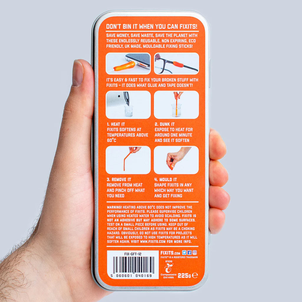 Hand holding an orange tin of fixits mouldable fixing sticks