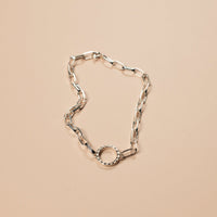 silver bracelet on a light pink background
