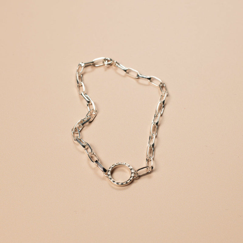 silver bracelet on a light pink background