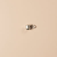 Small silver cup charm on a beige background