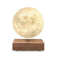 Levitating moon lamp on a wooden base against a white background