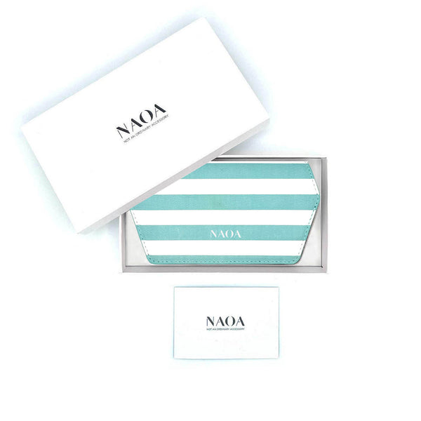 A blue and white stripped glasses case by NAOA, presented in a white box next to its white branded outer packaging and a small white card on a white background.