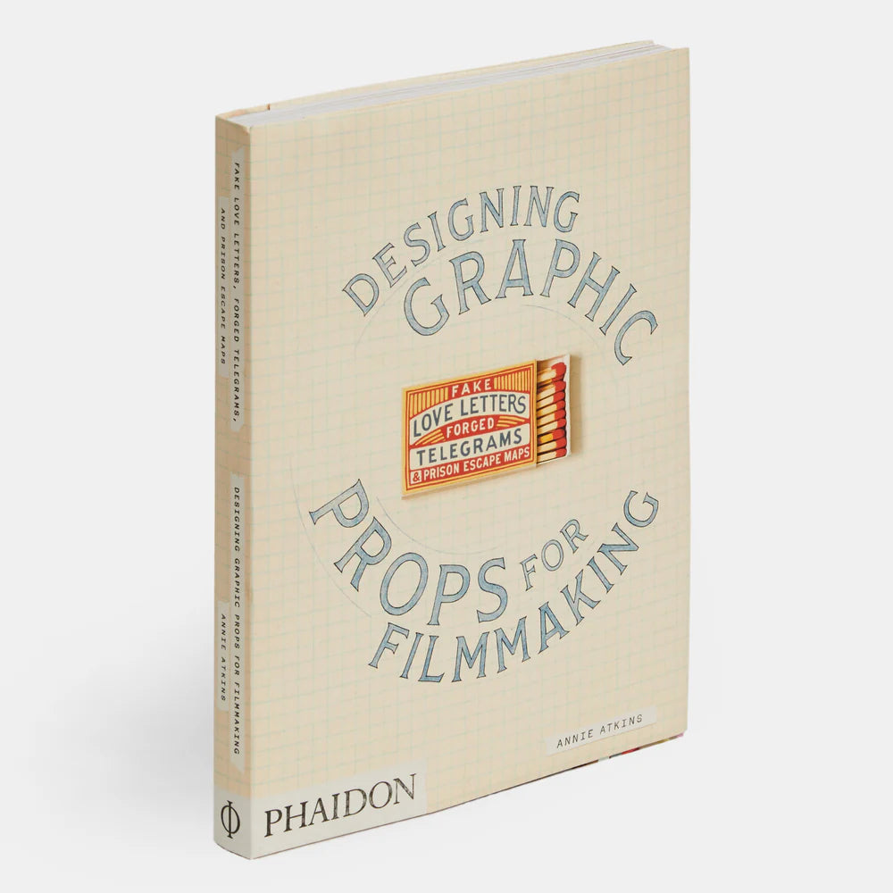 Book titled 'Designing Graphic Props for Filmmaking' with blue text on a beige grid background