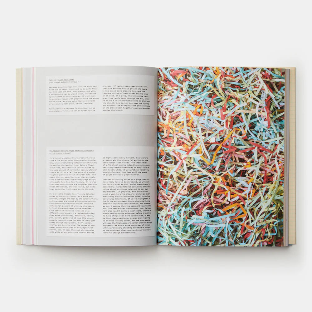 Open book with a picture of colourful shredded paper on one page and text on the other, on a white background.