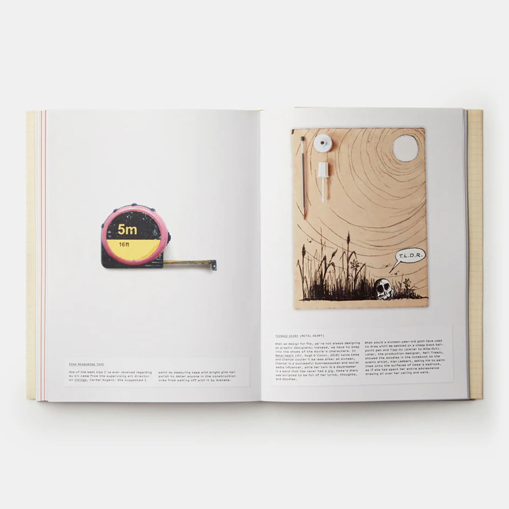 Open book showing illustrations of a tape measure and wooden board with a skull and grass design.