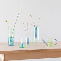 A collection of blue and green glass ornaments on a wooden table.