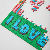 Jigsaw puzzle with colourful pieces spelling on a white background