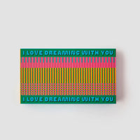 Rectangular puzzle box with colorful pattern and text 'I LOVE DREAMING WITH YOU' on a light gray background