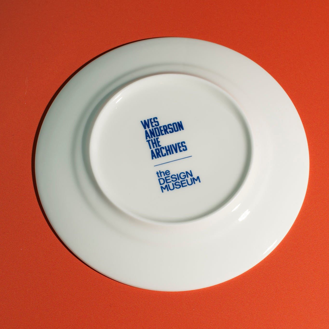 The back of a white plate with blue text on a red background