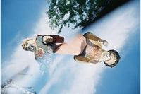 A photograph of two totem pole figures against a blue sky