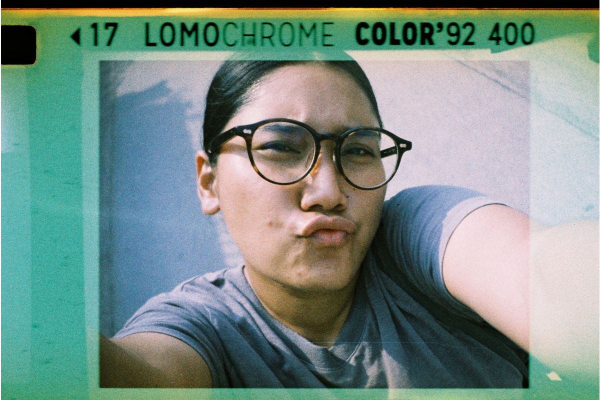 Person wearing glasses with a LomoChrome Color '92 400 film effect overlay