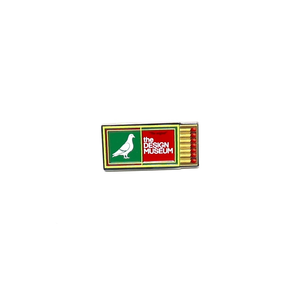 green and yellow matchbox pin badge with 'The Design Museum' logo on a white background